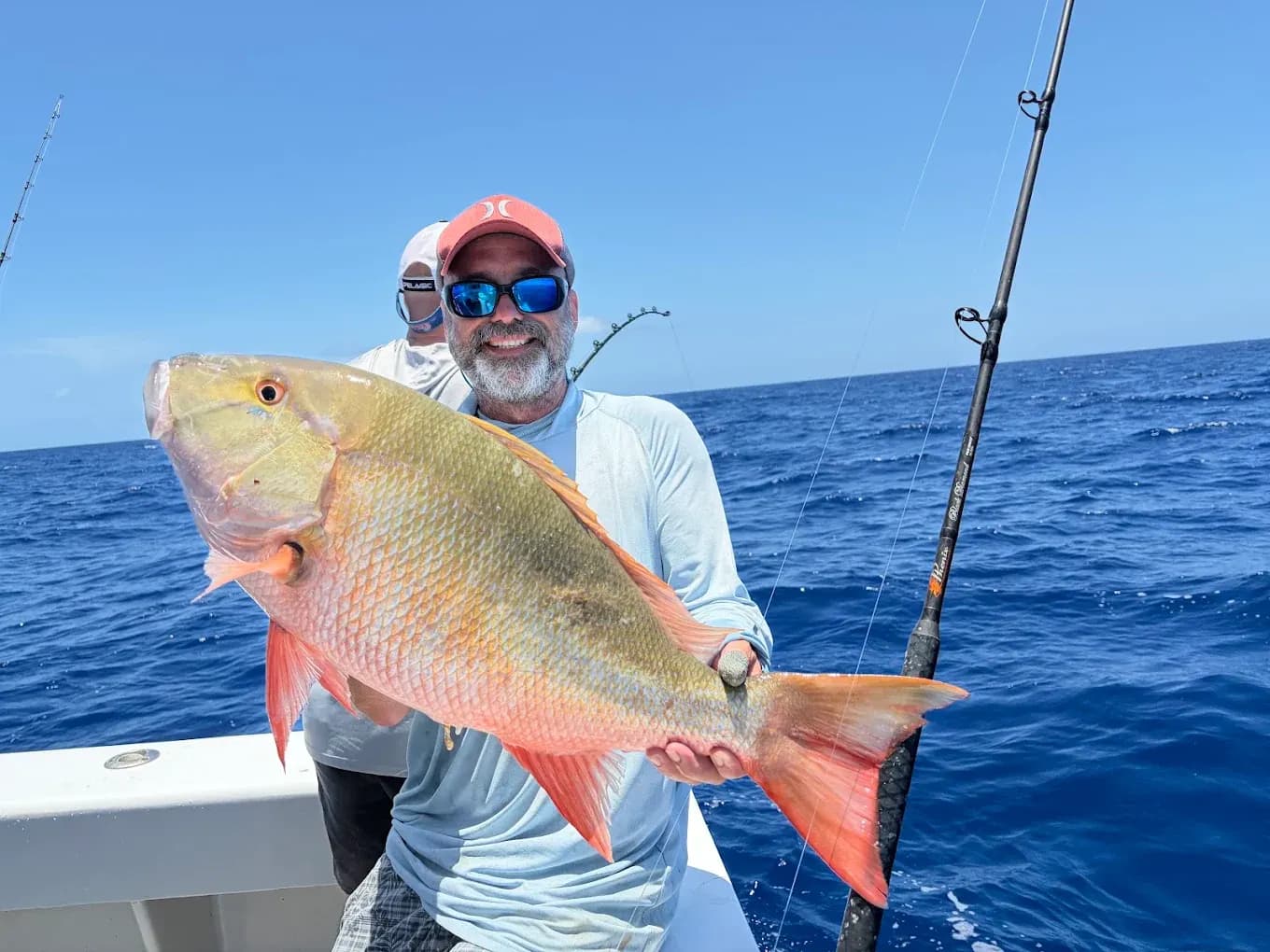 Offshore charter — an angler with a mutton snapper over deep blue water