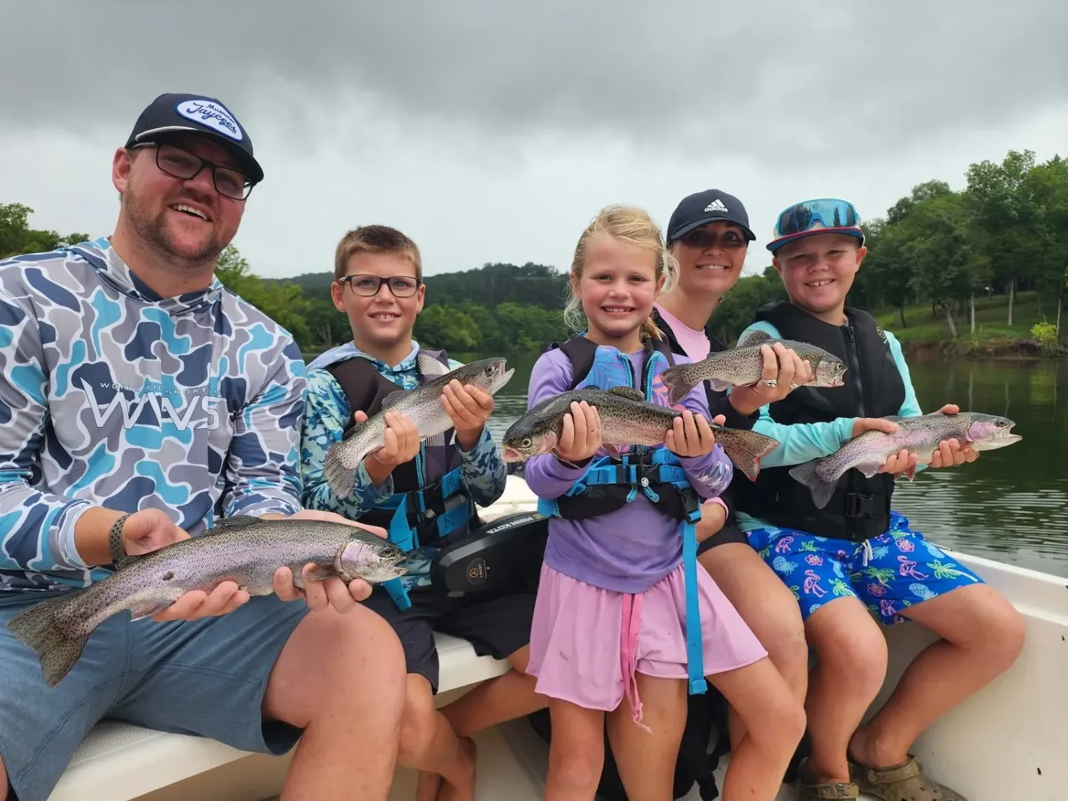 A family proudly holding their catch on a guided charter
